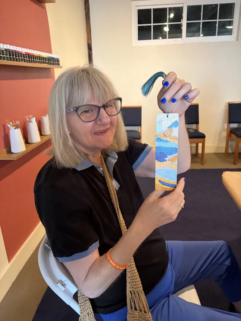 A member shows off the hand-painted bookmark she made in arts and crafts